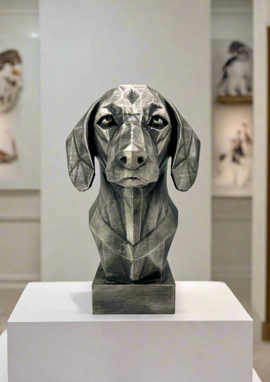 A geometric style 3D printed black and silver bust of a Dachshund, displayed on a white surface.