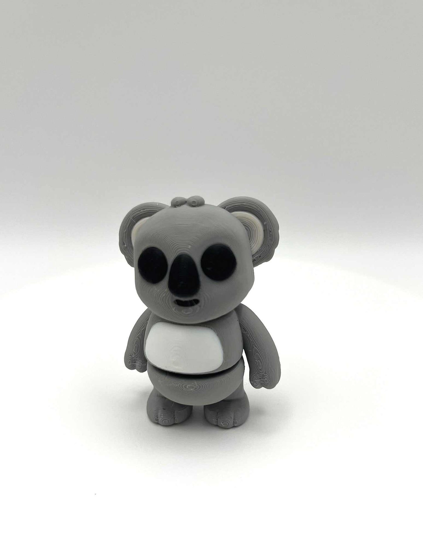 A cute Koala mini figure in a standing pose with big eyes, little ears and a round body. Perfectly pocket sized.