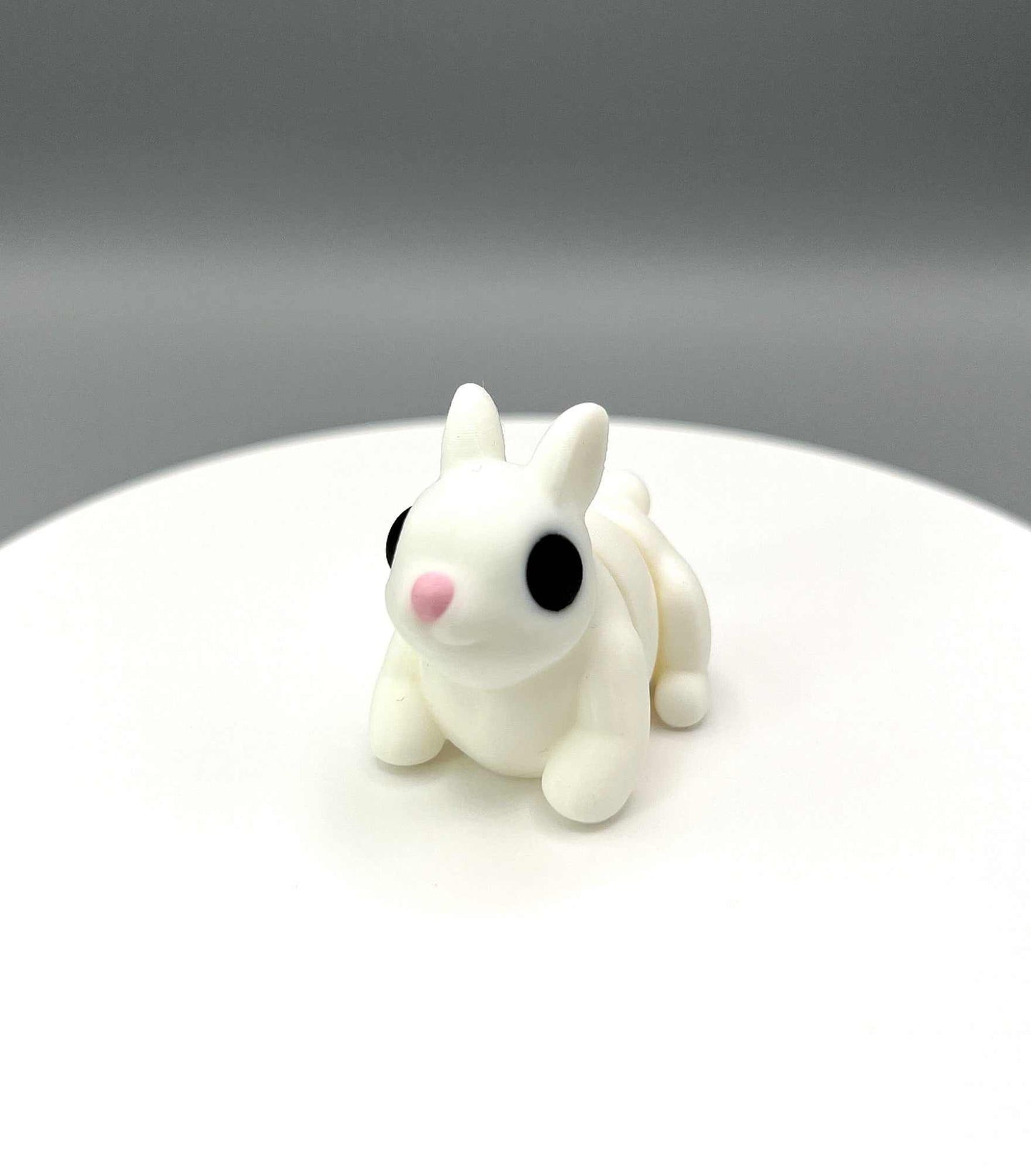 A super cute 3D printed little Bunny Mini figure with perky ears, a tiny pink nose, and articulated body. Perfectly pocket sized