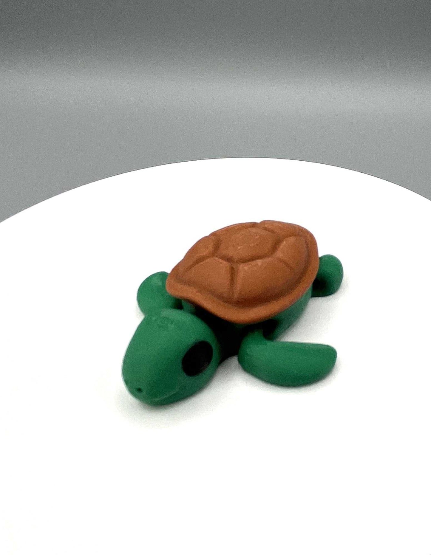 A 3D printed eco-friendly turtle mini figure with moveable legs and a textured shell. Perfectly pocket sized