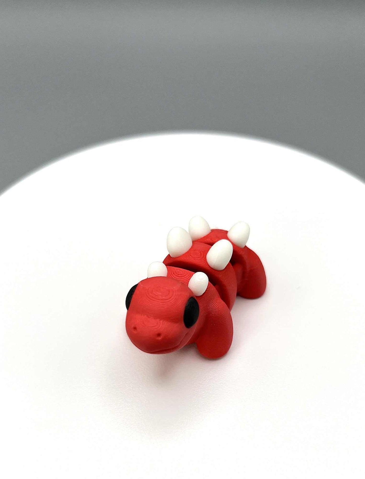 An eco-friendly 3D Printed Stegosaurus Mini Figure with little horns on its back and a cute face. Perfectly pocket sized.