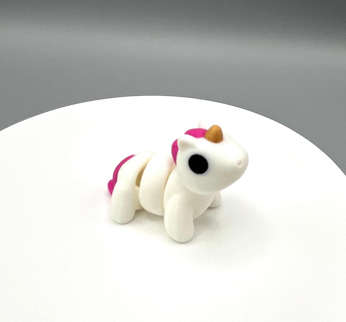 A 3D printed Unicorn Mini figure with a horn and mane and sweet expression. A very cute pocket sized companion.