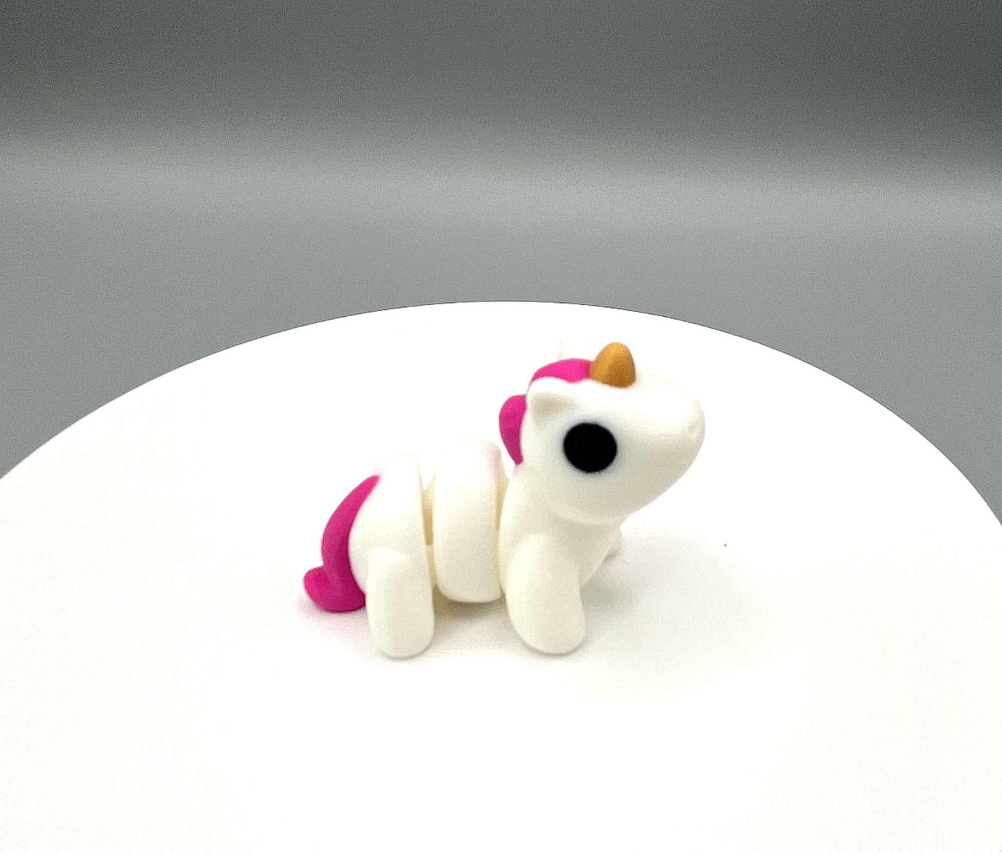 A 3D printed Unicorn Mini figure with a horn and mane and sweet expression. A very cute pocket sized companion.