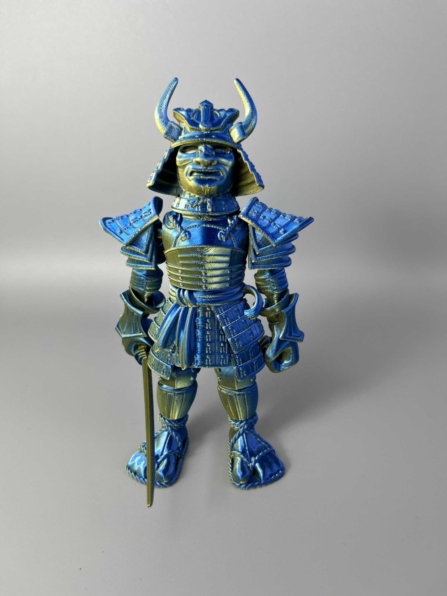 A large sized 3D Printed Samurai Warrior, wearing traditional Japanese armour and holding a detachable katana sword. Blue and Gold in colouring