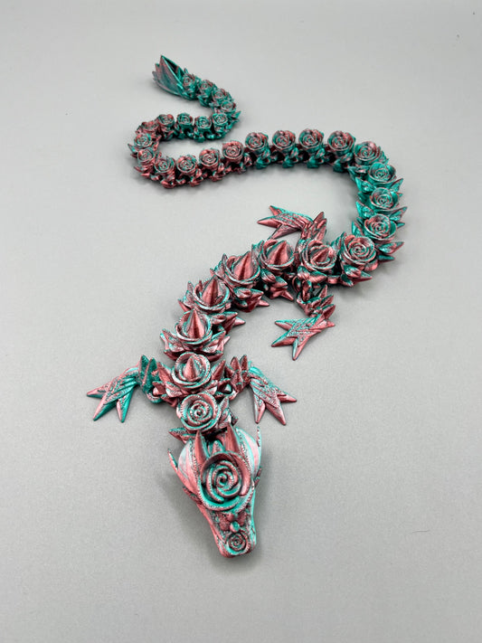 A 3D printed rose dragon, with flowers and thorns covering it's boy from head to tail.