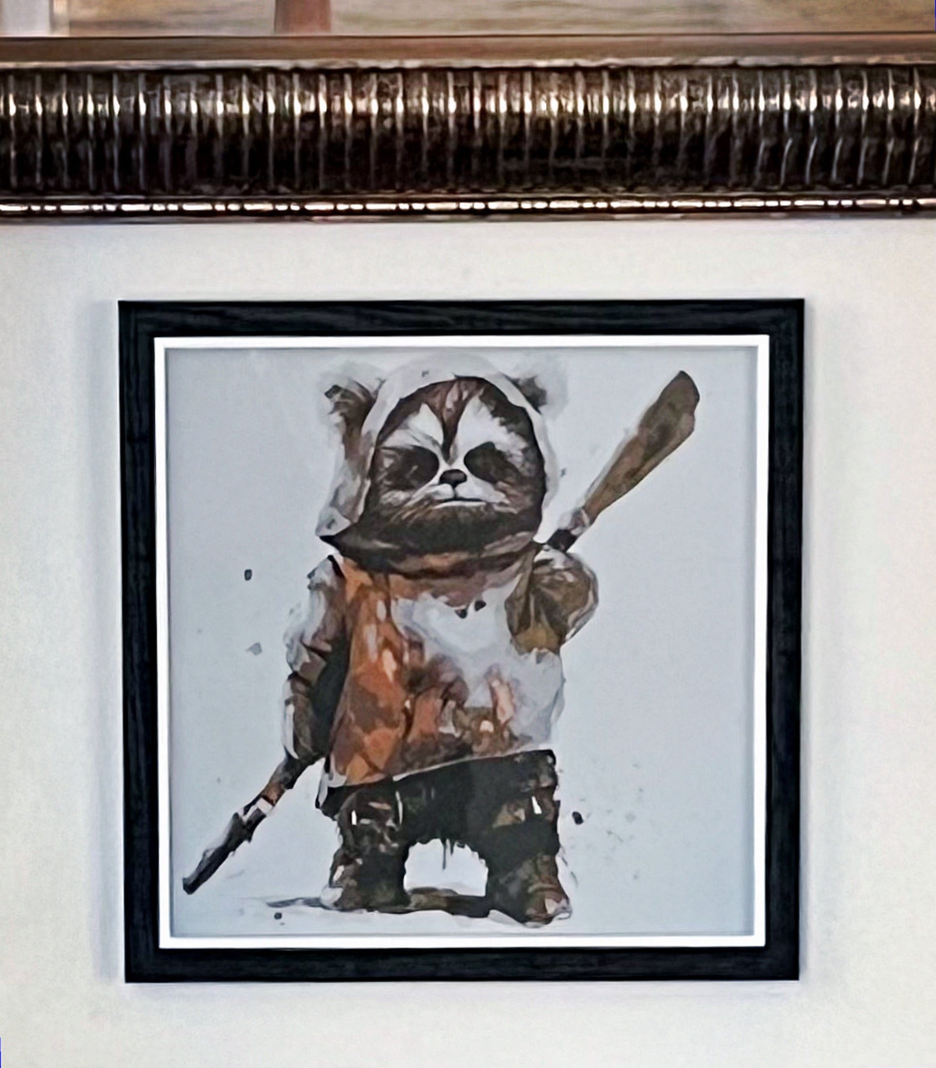A 3D printed textured picture of an Ewok in a black frame and hung on a wall