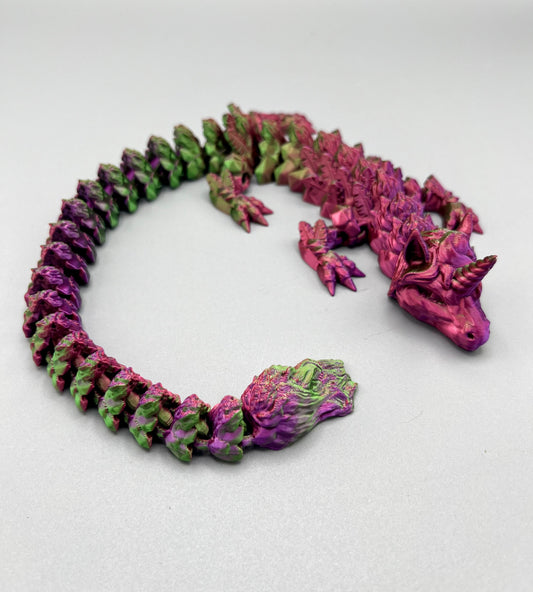3D Printed dragon with long articulated body and the head of a unicorn, set on a light grey background