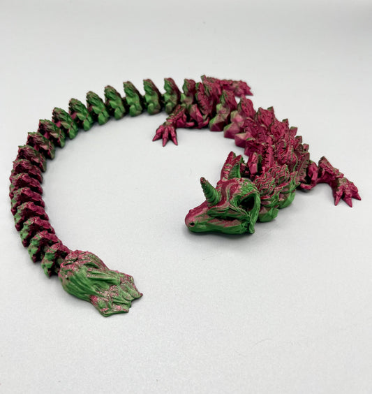 3D Printed dragon with long articulated body and the head of a unicorn, set on a light grey background