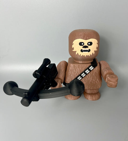 3D printed character with textured body and face, holding a weapon. Set on a light grey background.