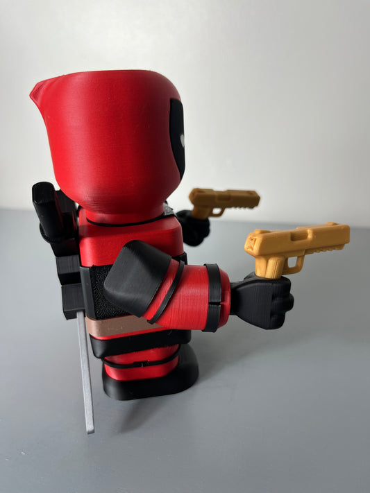 Side view of 3D printed superhero in red and black suit with mask, holding 2 guns and having 2 katana swords attached to his back