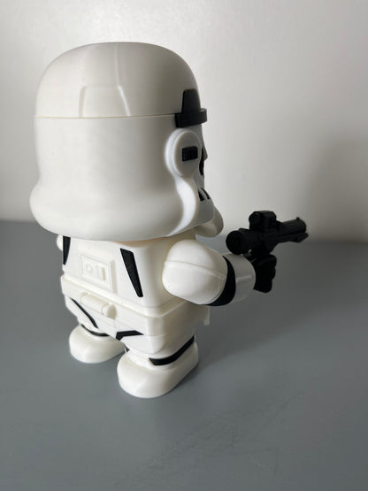 Back view of 3D printed film character in a white suit with white mask, holding a gun