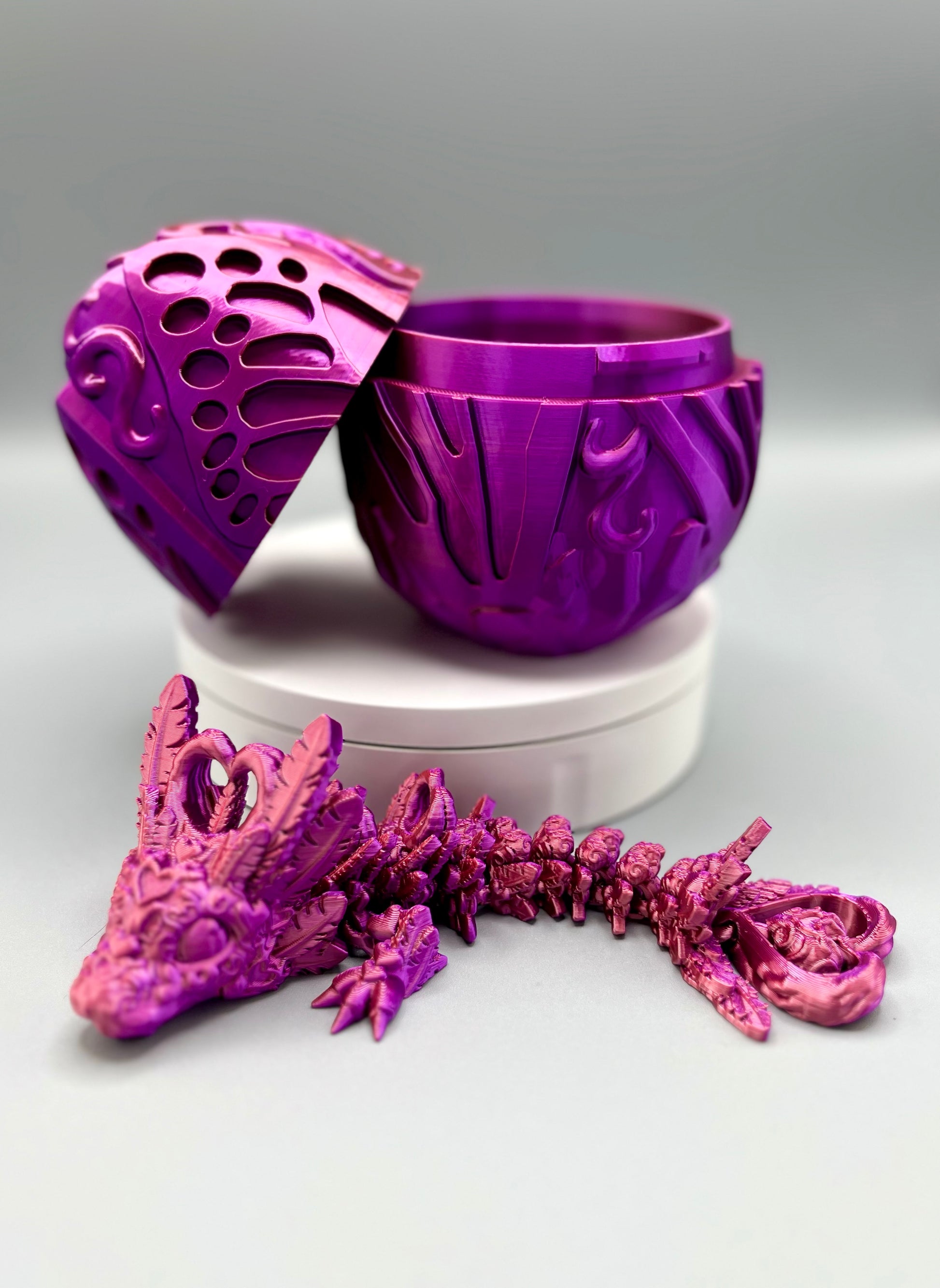 Opened 3D printed textured dragon egg and matching dragon, laying down, with heart and feather detailing all over from head to tail