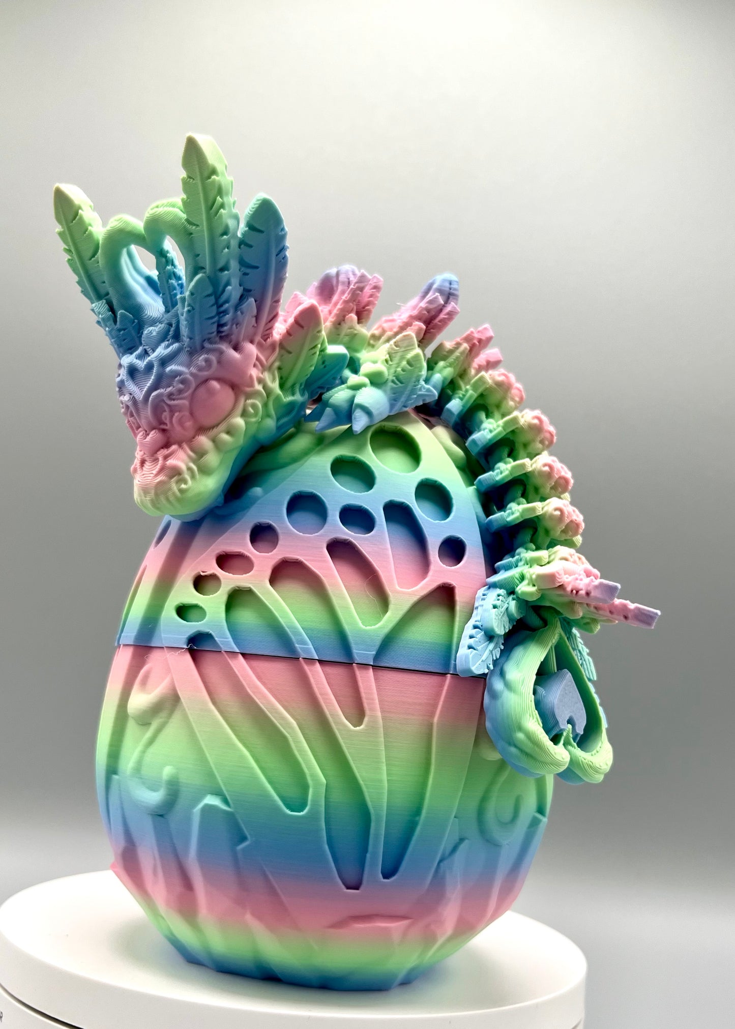 Beautiful 3D printed rainbow dragon egg with matching dragon perched on top, displaying textured heart and feather features all over it's head, body and tail