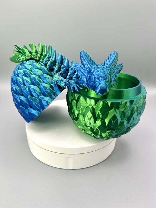 A 3D-printed set featuring a shiny axolotl dragon, sat over an open scaly egg, positioned on a white base.