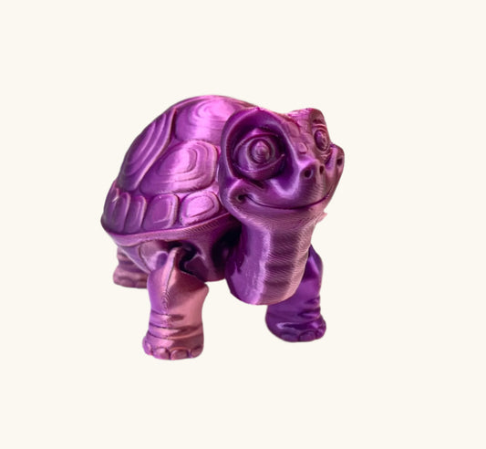 A cute 3D printed shiny pink and purple tortoise with detailed face, shell and legs