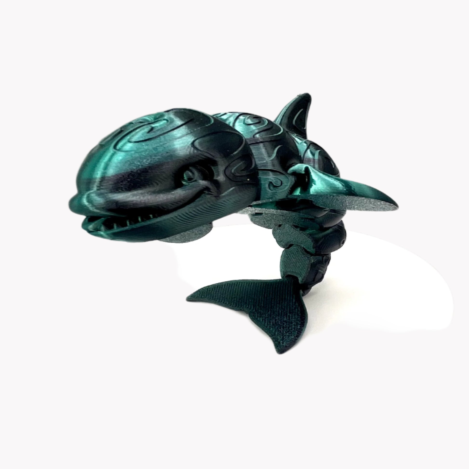 A 3D-printed orca with a tattooed all-over print, detailed facial features, including a smile, exposed teeth and tongue. Positioned standing on it's tail. Set against a white background.