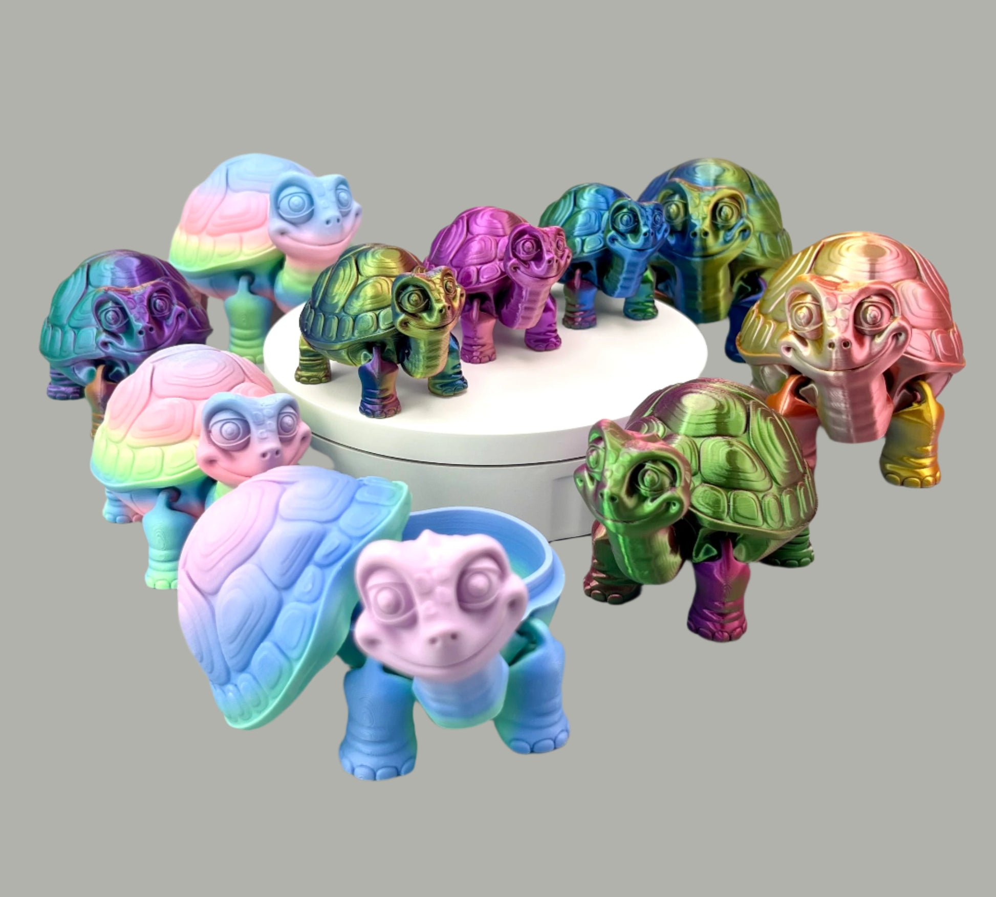 A picture full of cute, multi-coloured 3D printed tortoises, to show the full collection. Some are standing on a white display stand